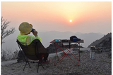 Enjoying a serene mountain sunset campsite with portable gear, perfect after an RV rental adventure.