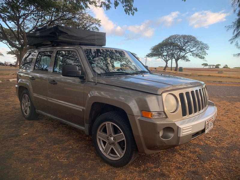 Gray Jeep Patriot SUV with a rooftop tent, an ideal RV rental for camping adventures. — photo 15