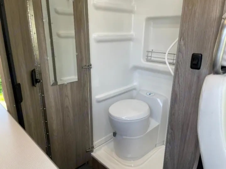  quilted rear seat with two 3-point seatbelts inside a camper van.|This RV rental offers a compact kitchen with a stainless steel sink — photo 5