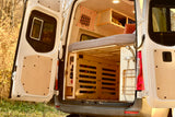 RV rental: van's custom interior with elevated bed, under-bed storage, and rear shower, seen through open doors.