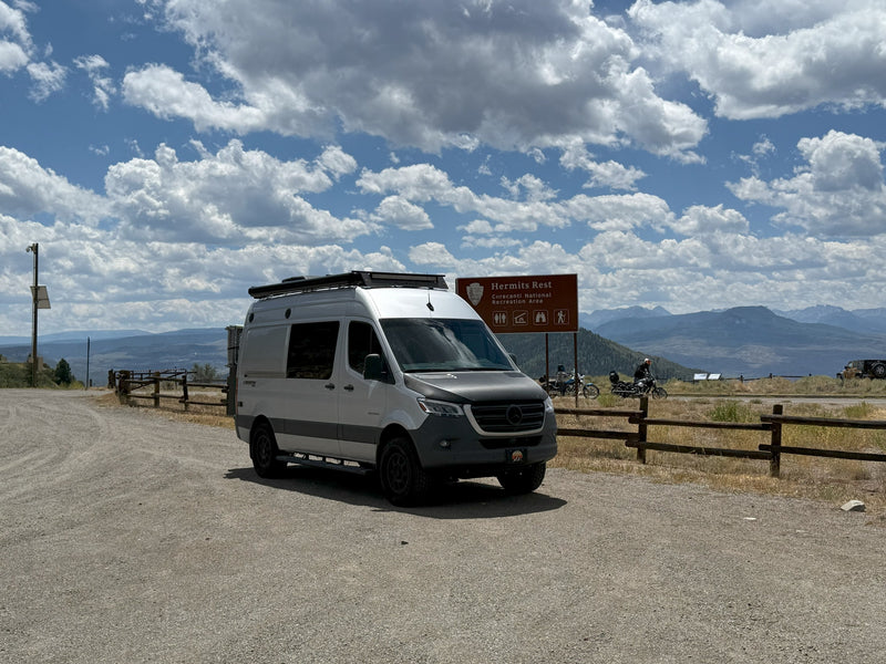  with its rear doors open revealing a cozy interior and a curious dog.|White Launch 4x4 rv rental van with spare tire — photo 7