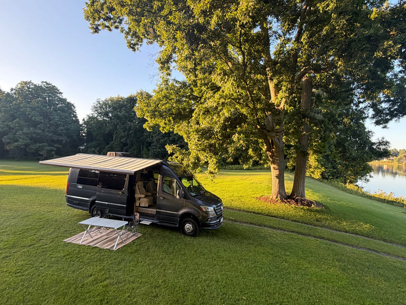 Scenic RV rental: a dark camper van with an extended awning — photo 1