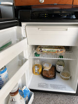 Inside an RV rental fridge: Organic eggs, juice, half & half, and ready-to-eat meals, perfect for road trip convenience.