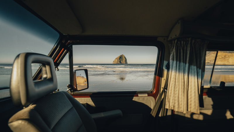 RV rental interior view of a serene beach, ocean waves, and a prominent sea stack. Perfect travel escape. — photo 6