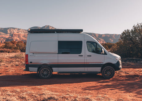 Modern Storyteller Overland MODE 4x4 camper van, a perfect rv rental for off-road adventures, parked in a scenic desert landscape.