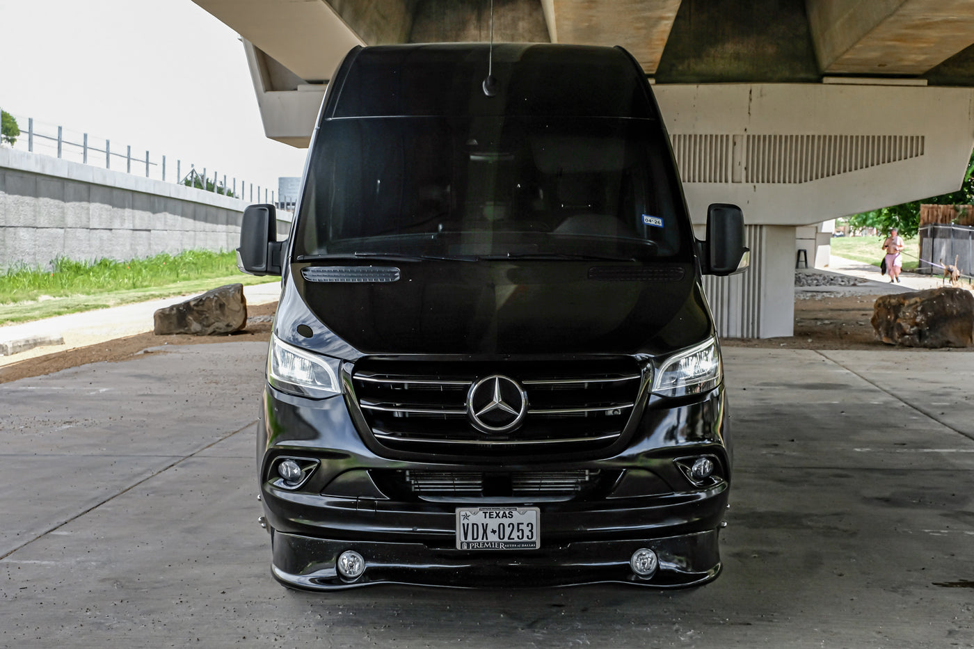 Black Mercedes Sprinter van, often used as an RV rental, parked under an overpass in Texas. — photo 2