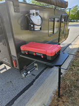 This Hiker Trailers RV rental features an outdoor kitchen setup with a portable propane stove and tank, perfect for camping.