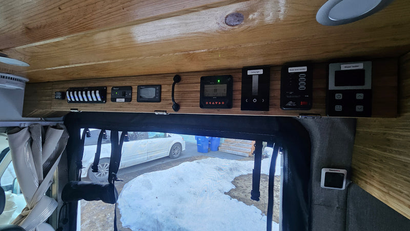 RV rental camper van's overhead control panel displays various systems: lighting, water heater, tank levels, solar, & thermometer. — photo 11