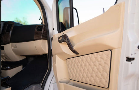 Passenger side of a luxury RV rental interior, featuring a cream door panel with quilted accents & wood grain dashboard.