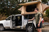 Man prepares for adventure with a truck rooftop tent, a great RV rental alternative for camping.
