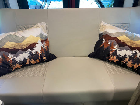 Comfortable RV rental seating with decorative mountain-themed pillows, perfect for relaxing on your road trip.