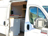 White camper van RV rental with side door open, revealing a cozy interior featuring a bed and kitchen counter.
