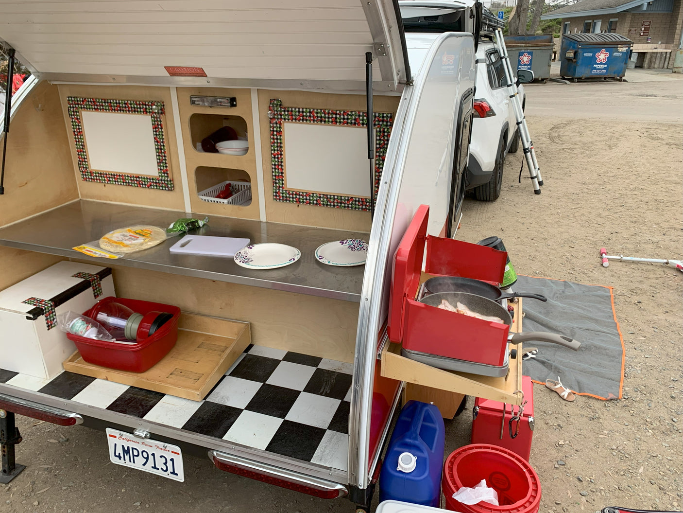 Enjoying outdoor cooking with this RV rental! Teardrop trailer galley shows bacon on the stove & counter space.