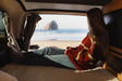 Serene beach view from an RV rental. A person relaxes inside