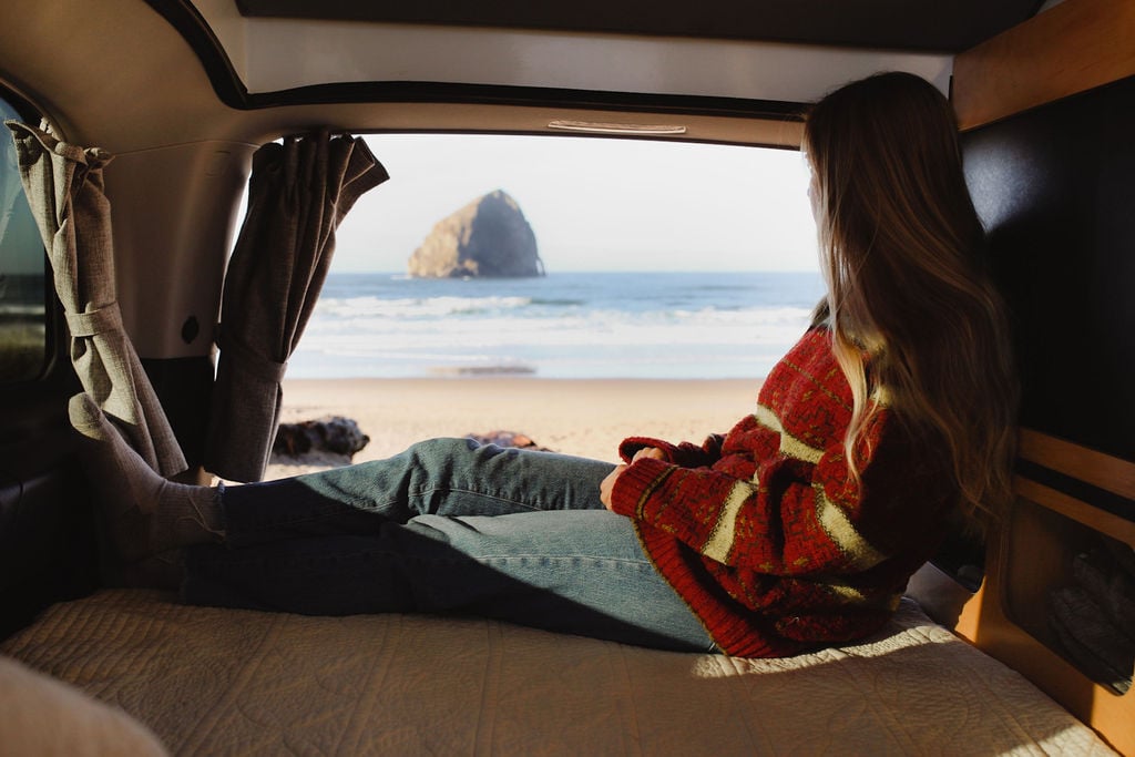Serene beach view from an RV rental. A person relaxes inside