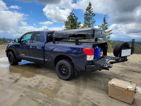 Exploring nature with a rigged-out truck, like an **rv rental** alternative! This blue Tundra features an Alpha rooftop tent & rear storage.