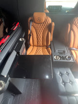 Luxury RV rental interior with plush Mercedes-Benz leather seats, a deployable table, and integrated amenities for premium travel.