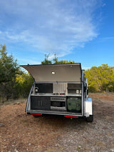 RV rental: Modern teardrop trailer featuring a well-appointed outdoor kitchen, perfect for camping adventures.