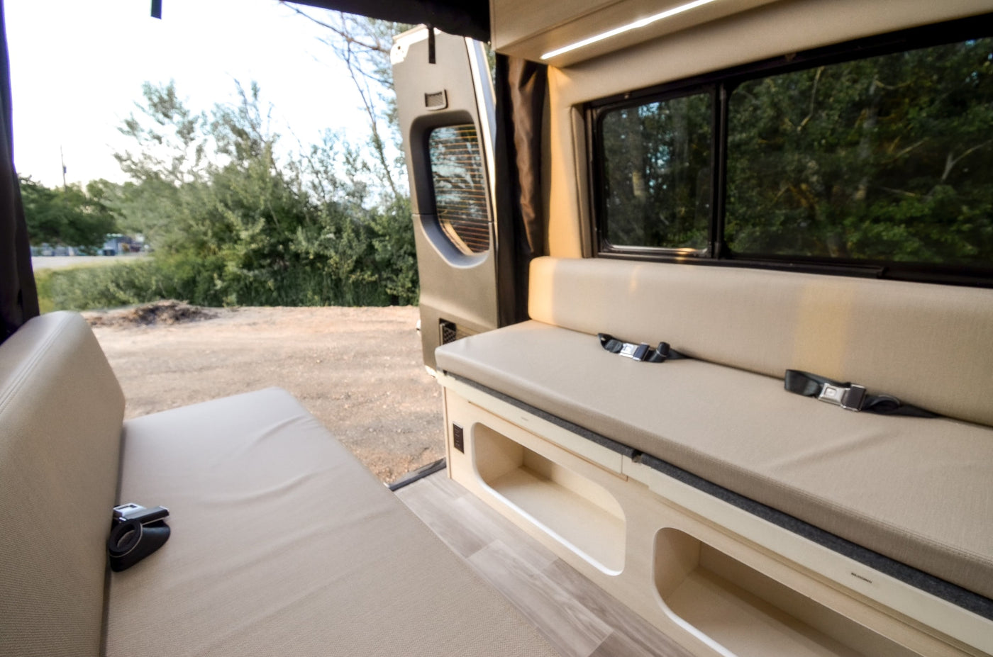  and a glimpse of the compact bathroom.|Explore this modern RV rental interior featuring a functional kitchen with sink — photo 6