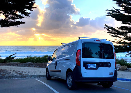 White van parked at a stunning ocean sunset. Imagine your next rv rental adventure here!