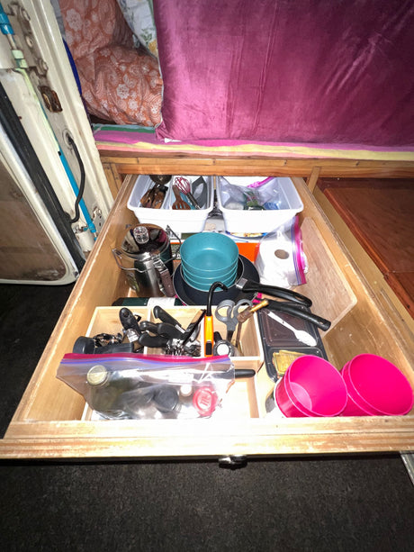 RV rental kitchen drawer: A practical, organized space with cooking pots, utensils, and camping supplies.