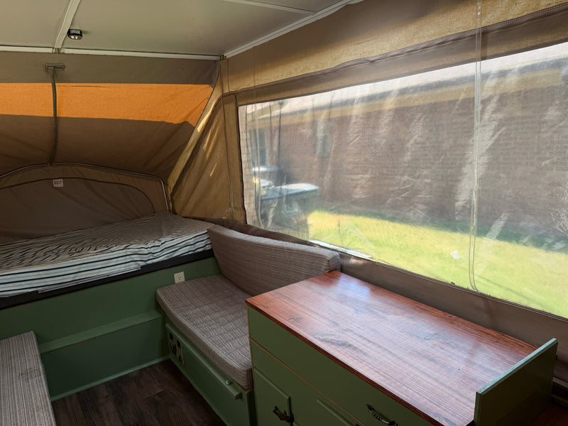  and a cozy bed. Perfect mobile dwelling.|View inside an RV rental showing green benches with textured cushions — photo 9