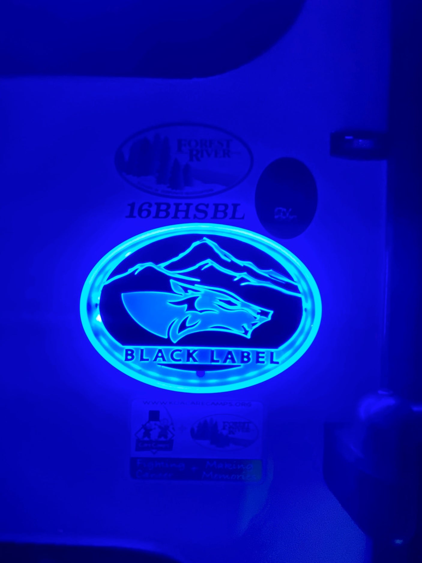 Illuminated "Black Label" wolf logo and "Forest River 16BHSBL" on an RV interior wall, perfect for your next RV rental.