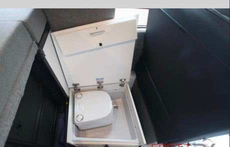 Hidden portable toilet inside a space-saving pull-out compartment, a convenient feature for an RV rental.