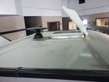 Discover features of an RV rental: close-up of an open rooftop skylight, antenna base, and roof rails on display.