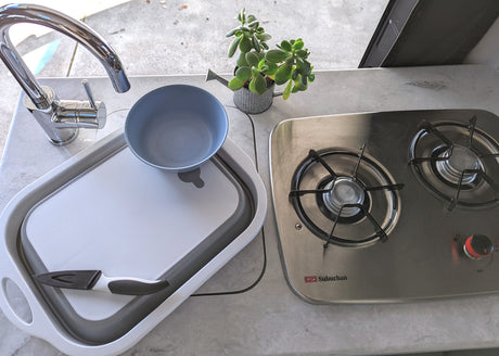 Experience our RV rental kitchen, featuring a full sink, Suburban stove, and space-saving basin.