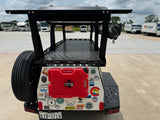 Overland trailer loaded with gear, parked near RVs and Budget RV rental trucks, ready for outdoor adventure.