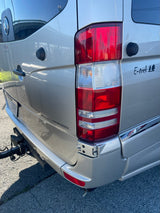Rear view of a silver Roadtrek E-trek camper van, showing its taillight, E-trek logo, and tow hitch, perfect for an rv rental adventure.