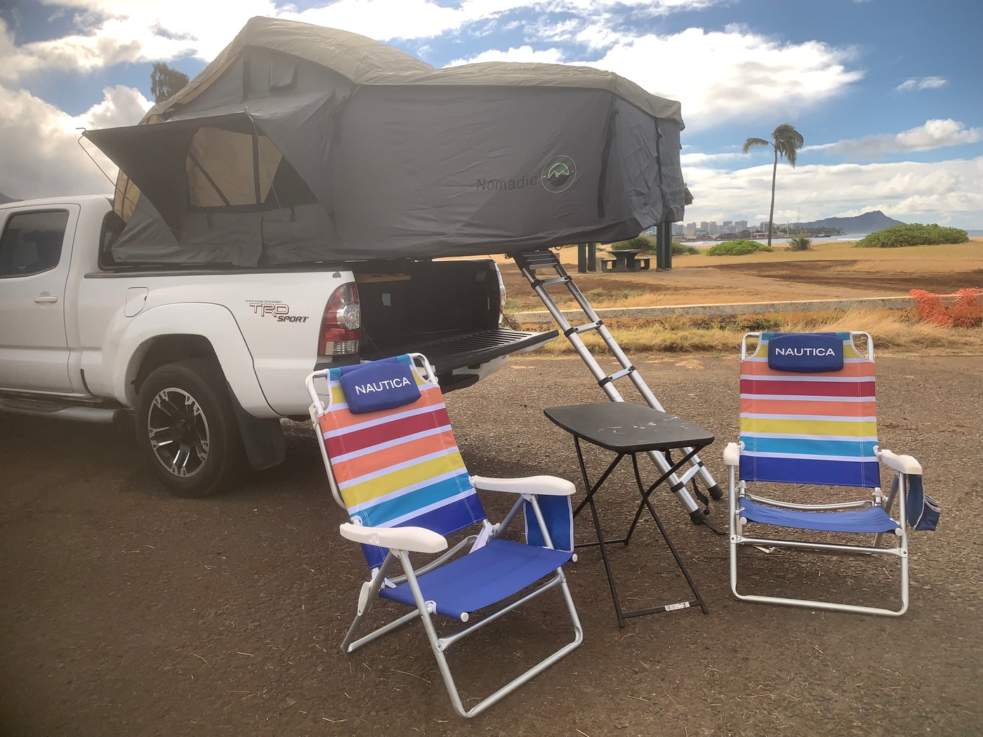 White Toyota pickup with a Nomadic rooftop tent