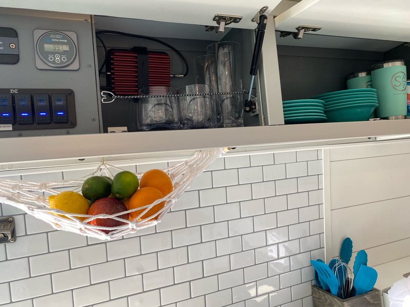  and unique blue ceiling lights.|Compact RV rental kitchen with a cooktop/oven — photo 4