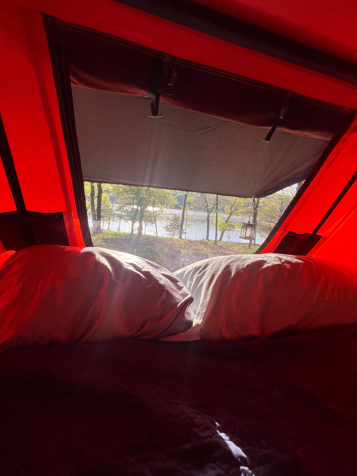 RV rental view: Waking up to a serene lakeside view from inside a cozy camper, with pillows in the foreground. — photo 5