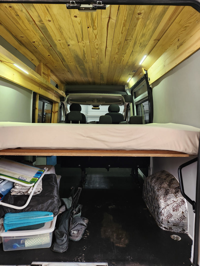  featuring wooden storage & LED lighting. Shows vehicle rear.|A white conversion van — photo 3