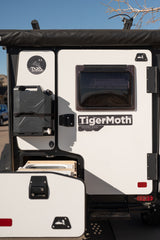 Explore with this Taxa Outdoors TigerMoth Overland Edition RV rental, featuring a mounted jerry can and pull-out kitchen.