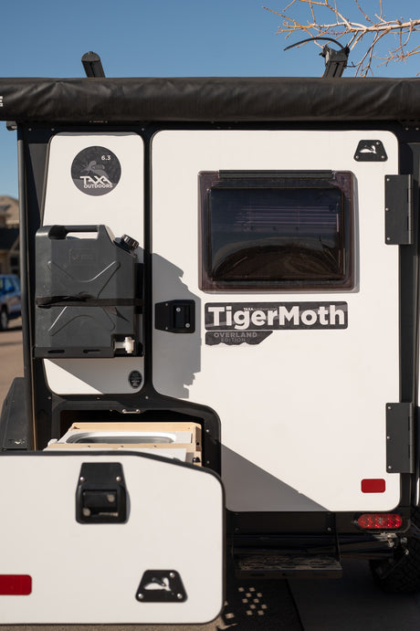 Explore with this Taxa Outdoors TigerMoth Overland Edition RV rental, featuring a mounted jerry can and pull-out kitchen.