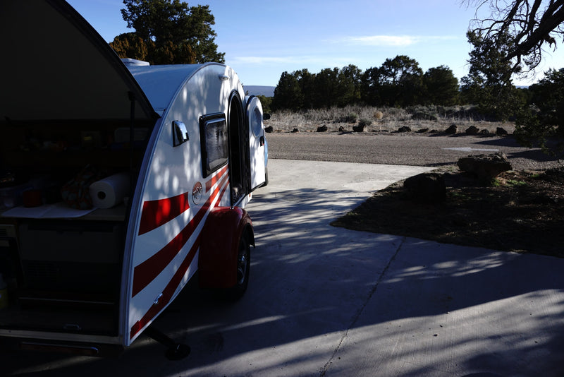 T@G teardrop camper rv rental, rear galley & side door open, parked outdoors in dappled sunlight. — photo 9