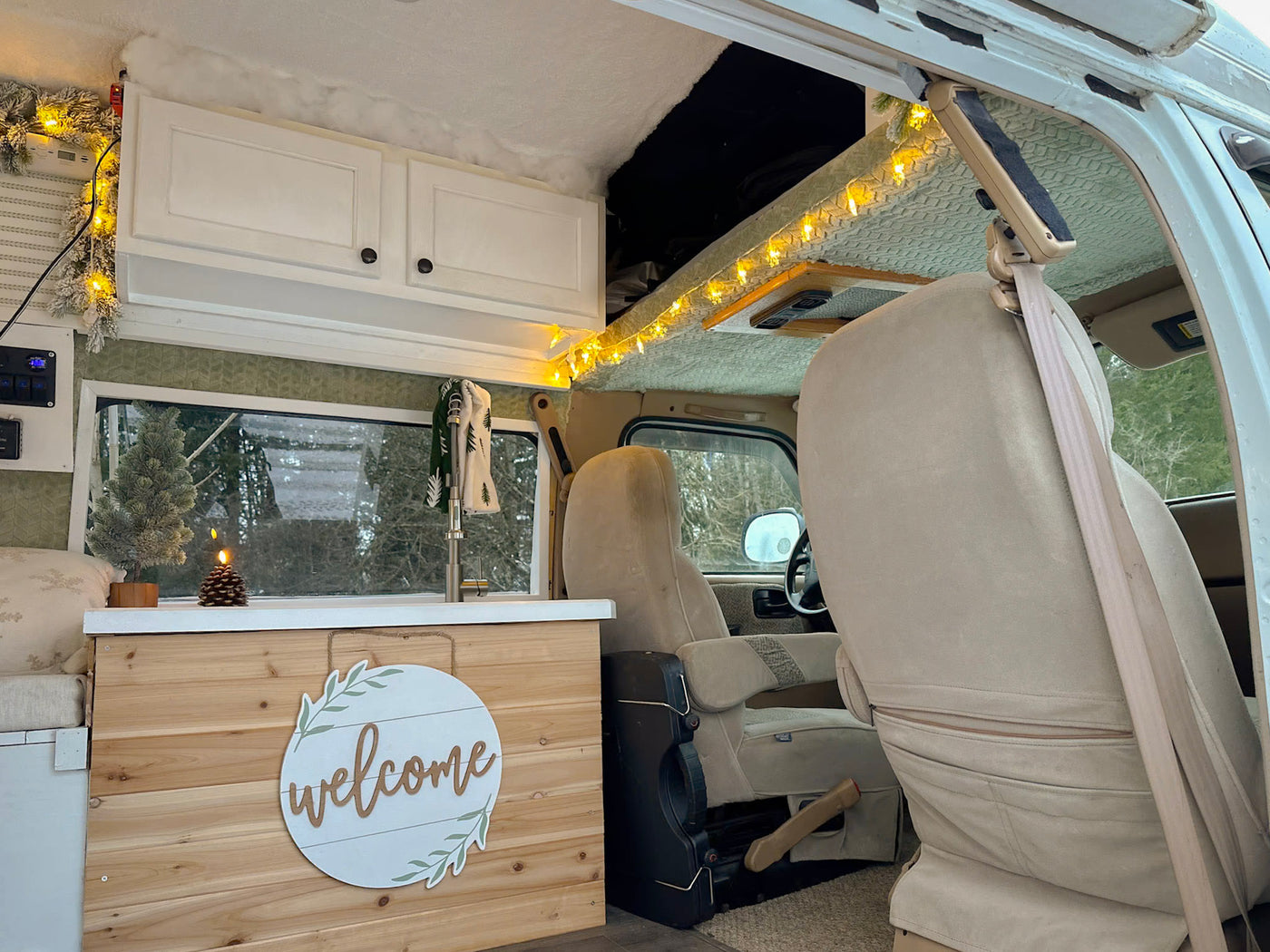  perfect for a holiday getaway.|Step inside this festive RV rental. A cozy camper van interior with holiday lights — photo 4