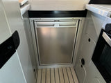 Inside an RV rental: a Dometic compact refrigerator and freezer, built into a modern kitchen area.