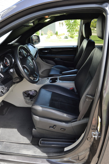 Spacious minivan interior, driver's view with steering wheel & black leather seats. Perfect for family travel or an RV rental journey.
