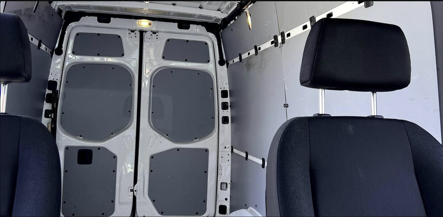 Rear cargo area & front seats of a clean van, ideal for RV rental conversions or transport.