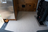 An RV rental's practical interior: Dometic fridge, custom wood storage, and versatile passenger seating.
