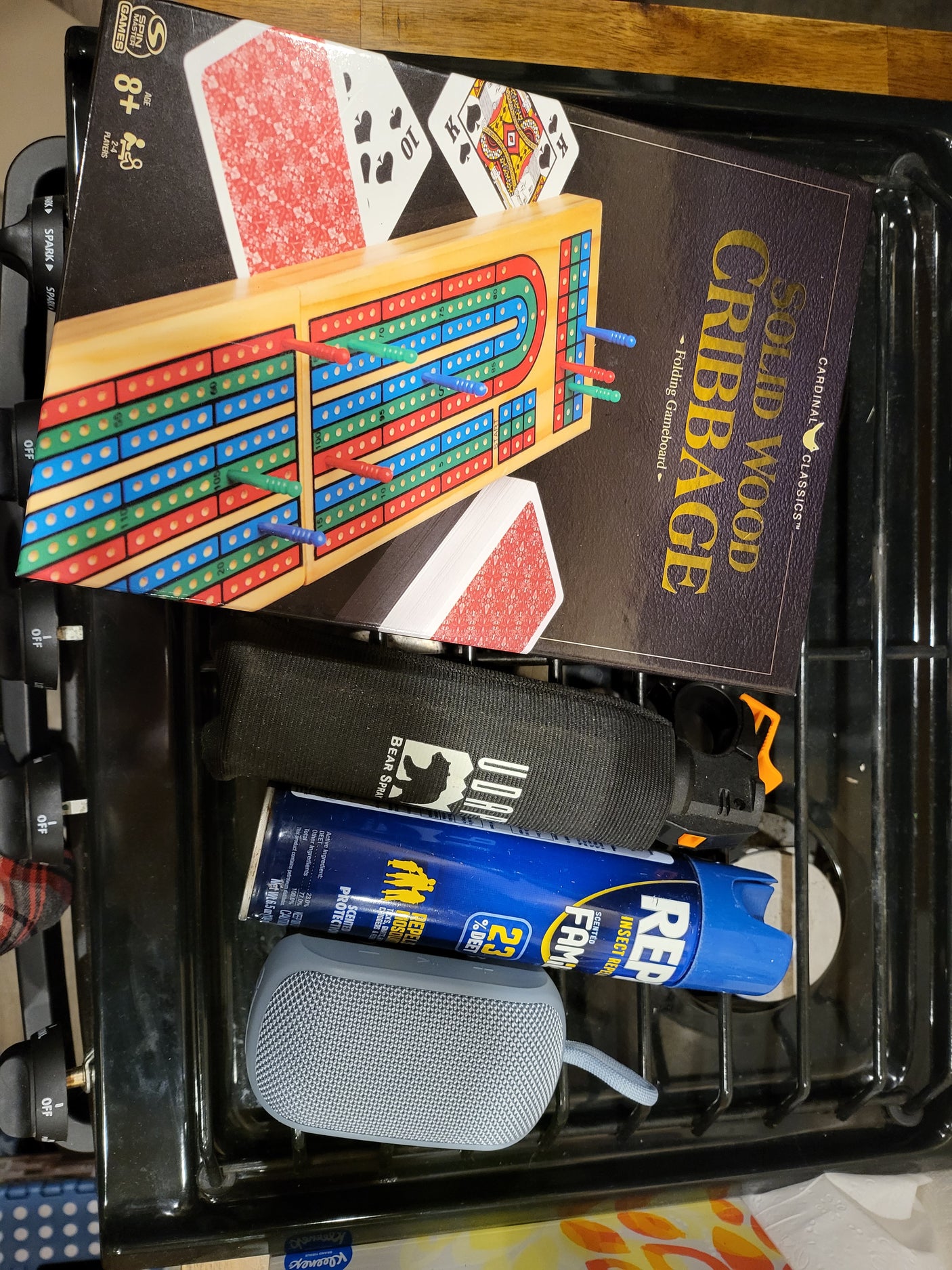 RV rental prep: Cardinal Cribbage, UDAP Bear Spray, Repel insect repellent, and a portable speaker for the trip.