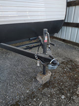  is parked on gravel in a storage shed with its door open.|A Coleman RV rental