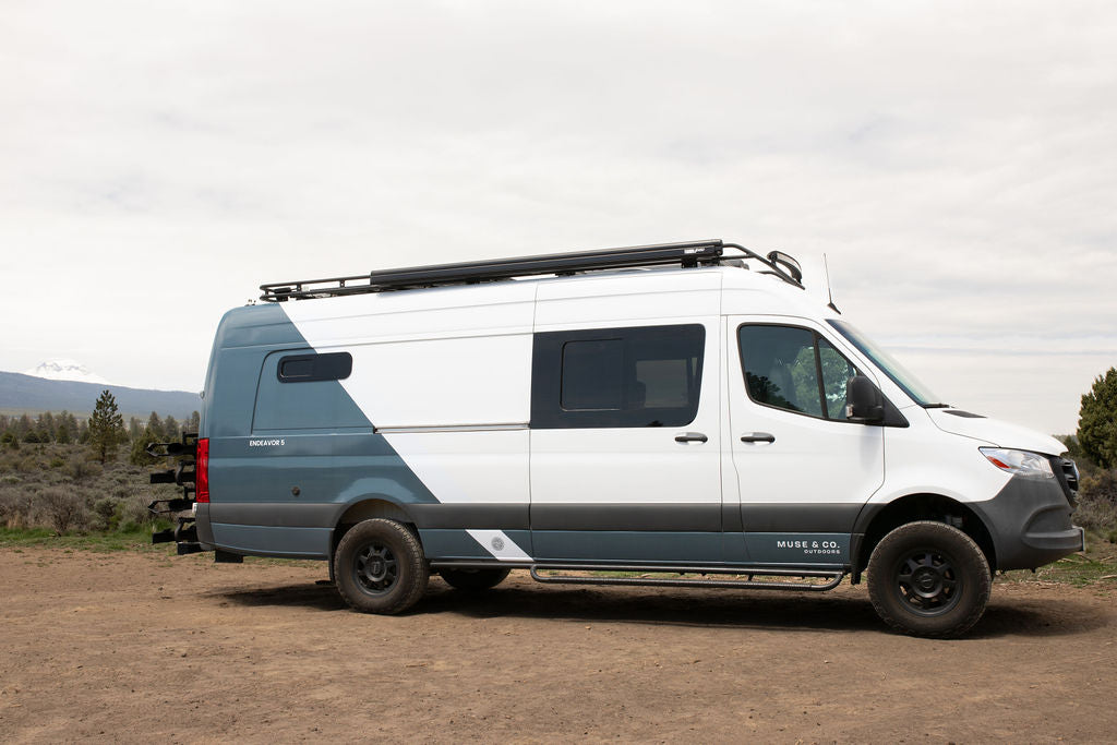 Adventure-ready white & grey custom camper van, ideal rv rental for outdoor road trips with mountain views.