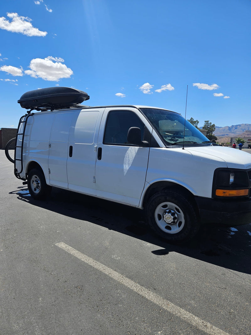  parked outdoors amidst tall pine trees under sunny skies.|This RV rental offers a cozy camper van interior — photo 11