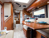 Experience a comfortable RV rental interior: spacious dining area with wine, kitchen, and cozy seating for your travels.