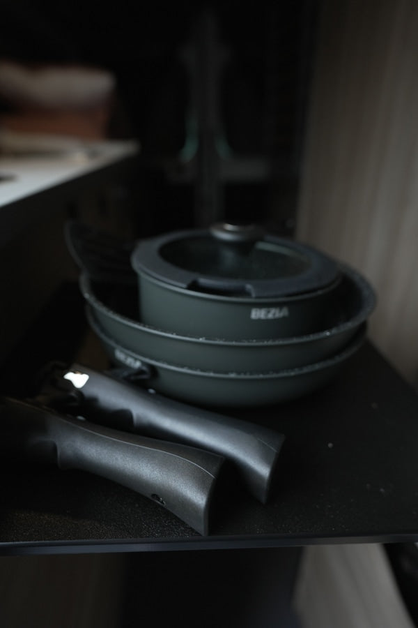 Essential dark grey cookware set with detachable handles, including pots, lid (BEZIA brand), perfect for an RV rental kitchen.